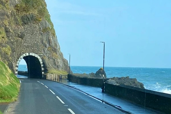 Coastal road tunnel carved into sea cliffs along Ireland’s scenic Atlantic coastline