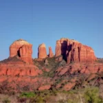 Scenic red rock formations in Sedona, Arizona with hikers on a popular trail during sunrise