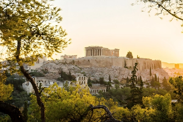 Panoramic view of the Acropolis and Parthenon temple at sunset on a limestone hill in Athens, Greece.