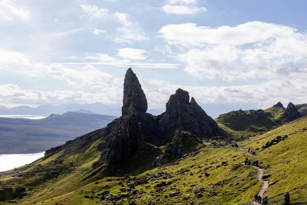 The Old Man of Storr hiking trail in the Isle of Skye, Scottish Highlands with hikers on the path.
