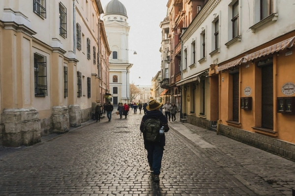 Solo traveler walking alone on cobblestone street in a historic European city, exploring walkable and safe travel destination in Europe