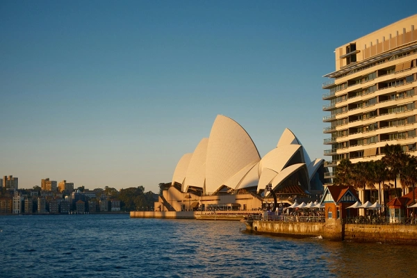 Sydney Opera House viewed across Sydney Harbour in warm evening light