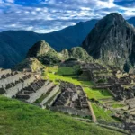 Machu Picchu ruins in the Andes Mountains, Peru with green terraces and dramatic clouds