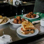 Townsville restaurant serving fresh burgers, wraps, and local seafood appetizers on a stainless steel counter.