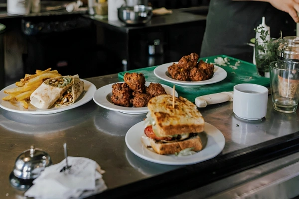 Townsville restaurant serving fresh burgers, wraps, and local seafood appetizers on a stainless steel counter.