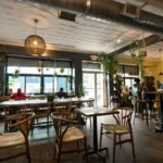 Cozy modern cafe interior in New York City with wooden seating, natural light, and people enjoying coffee