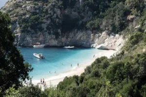 Small boats anchored in the turquoise cove of Grama Bay, Karaburun Peninsula, Albania.